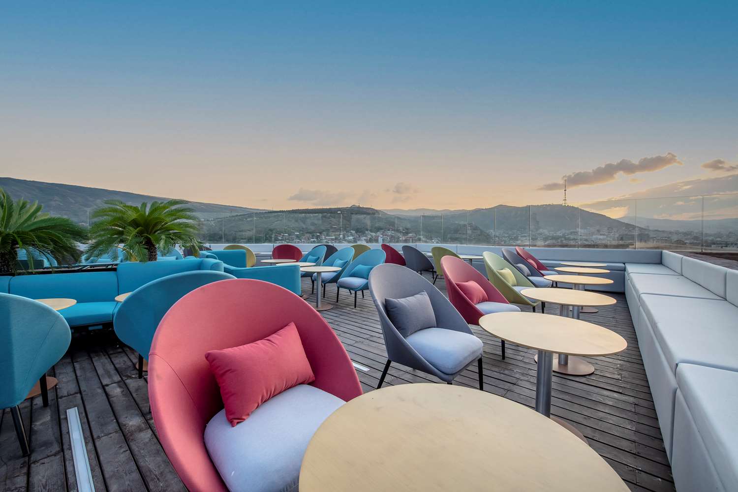 TITA rooftop terrace with colorful lounge seating and mountain views